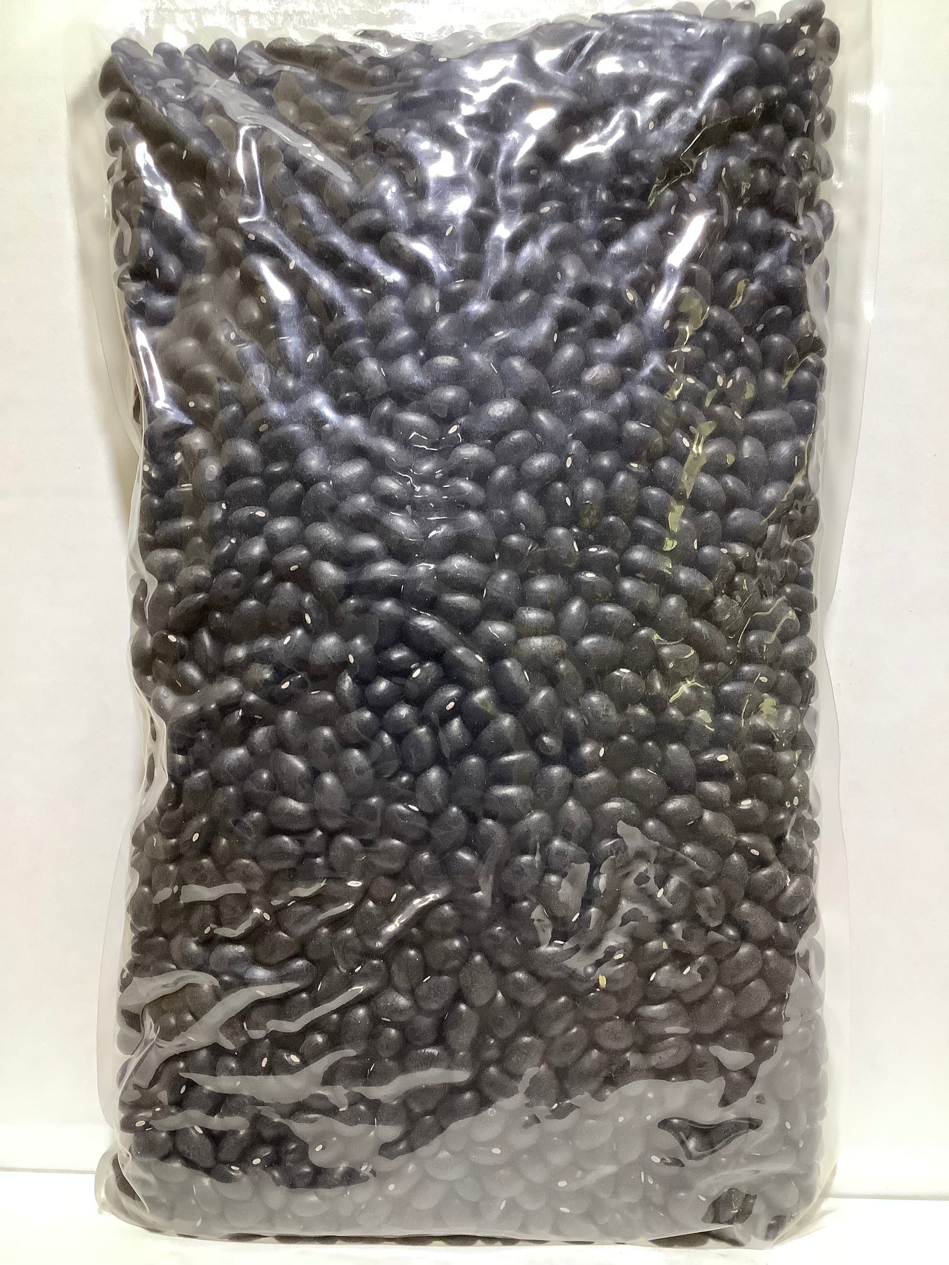Plastic bag filled with black beans on a white background